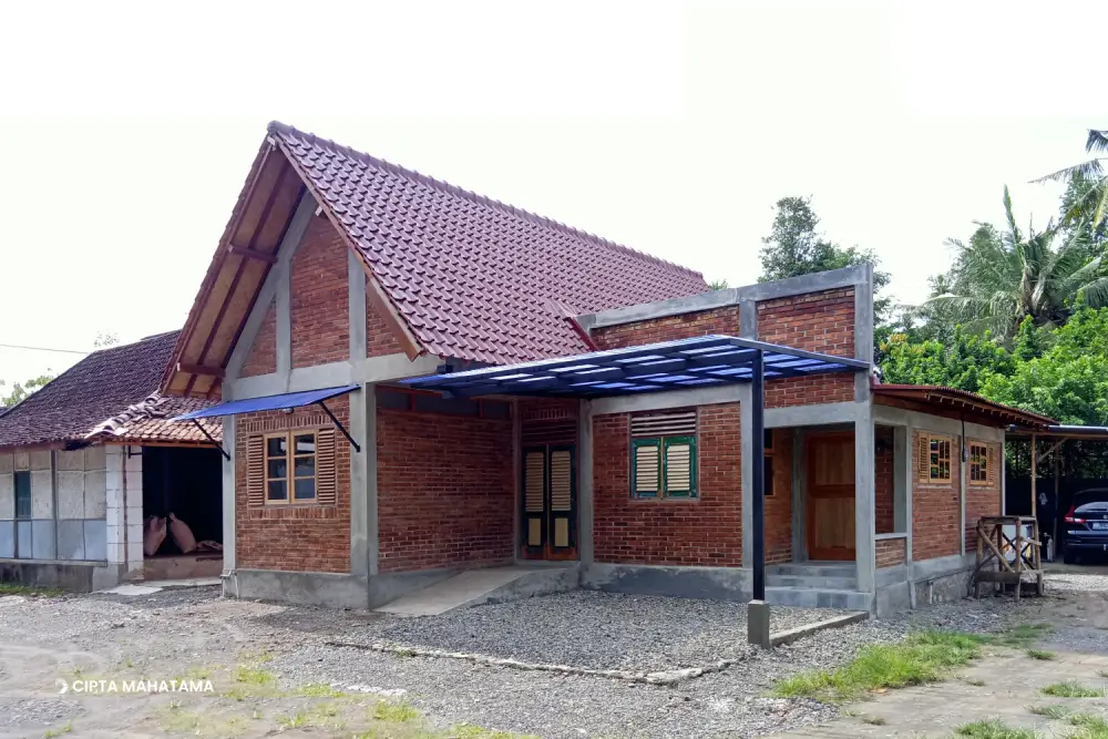Rumah Bata Ekspos di Bantul Yogyakarta Setelah Terbangun Rumah bata ekspos dengan atap curam dan rangka beton ekspos di Bantul Yogyakarta tampak depan.
